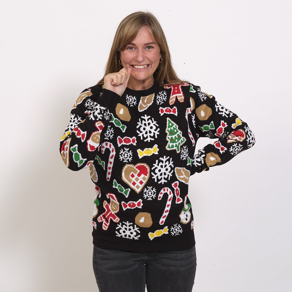 Une femme portant un pull de Noël noir avec des décorations de Noël.